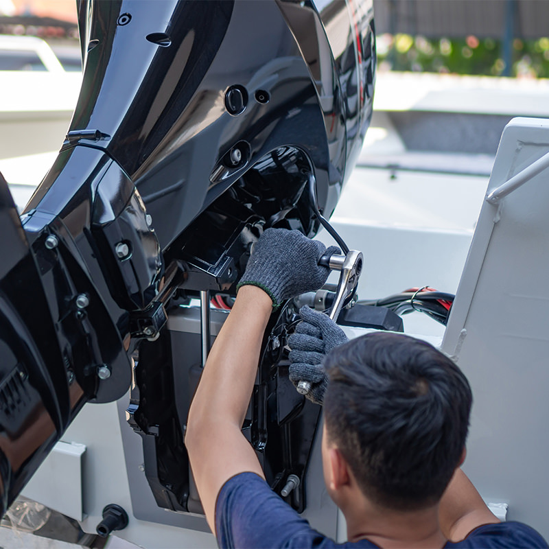 A man is servicing a yacht's engine