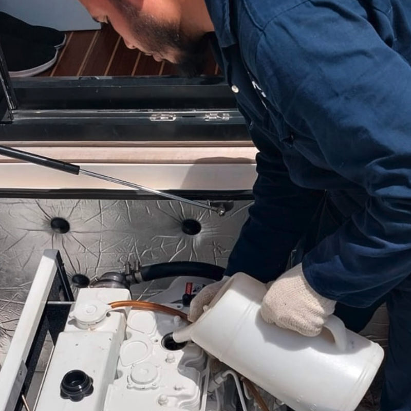 A man is refueling a boat engine with oil